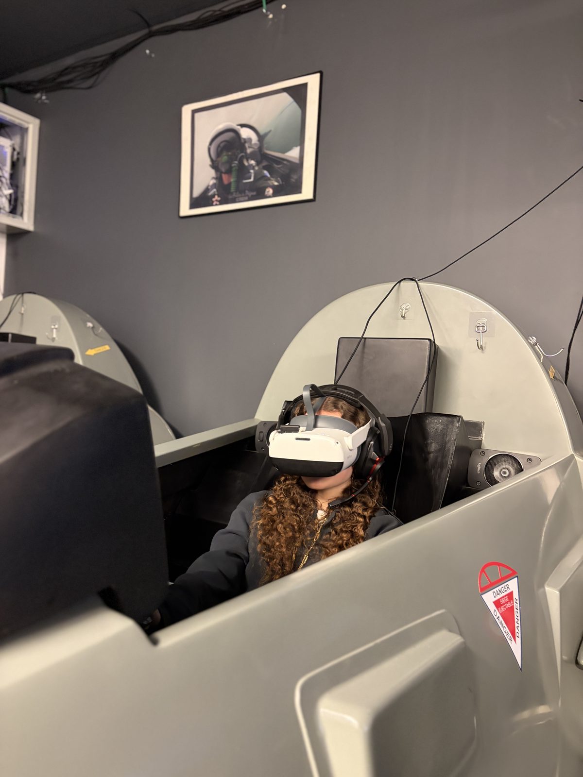 Une joueuse installée dans un cockpit du simulateur Mirage 2000 chez Team Square